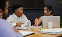 A trans person and a trans man discussing something in a meeting